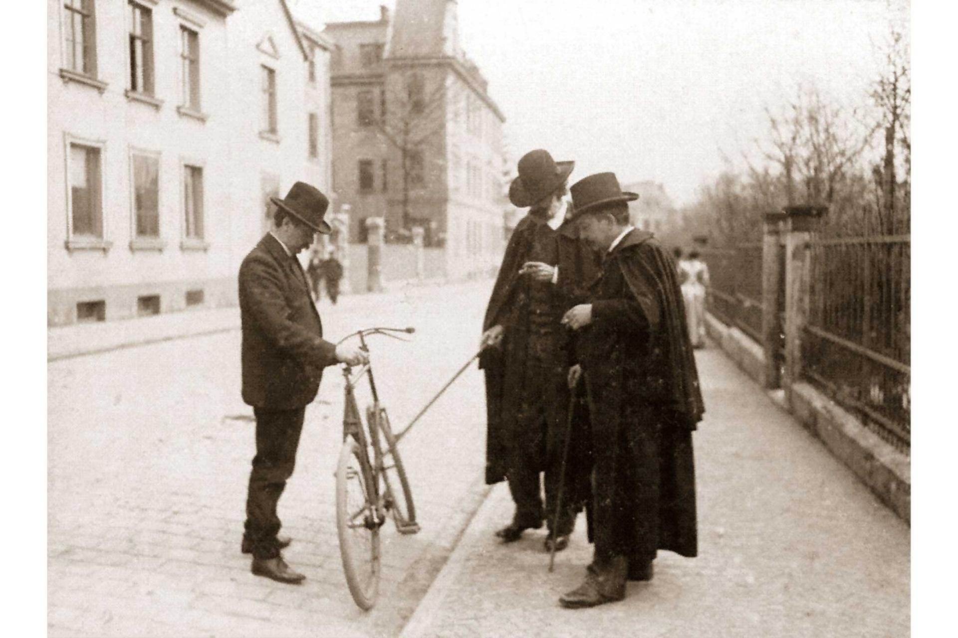 Ernst Abbe und Otto Schott begutachten das kettenlose Fahrrad von Paul Rudolph.