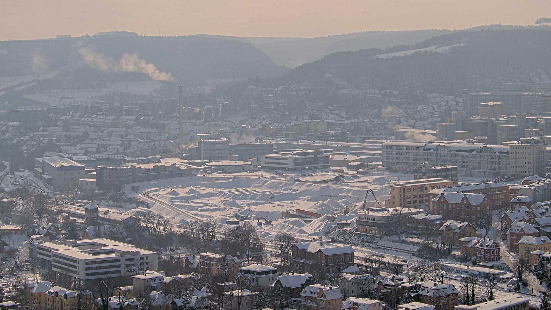 Ein Bild aus dem Livestream der Baustelle zeigt, wie der kurzfristige Wintereinbruch das Gelände zu einer unbekannten Winterlandschaft gemacht hat.