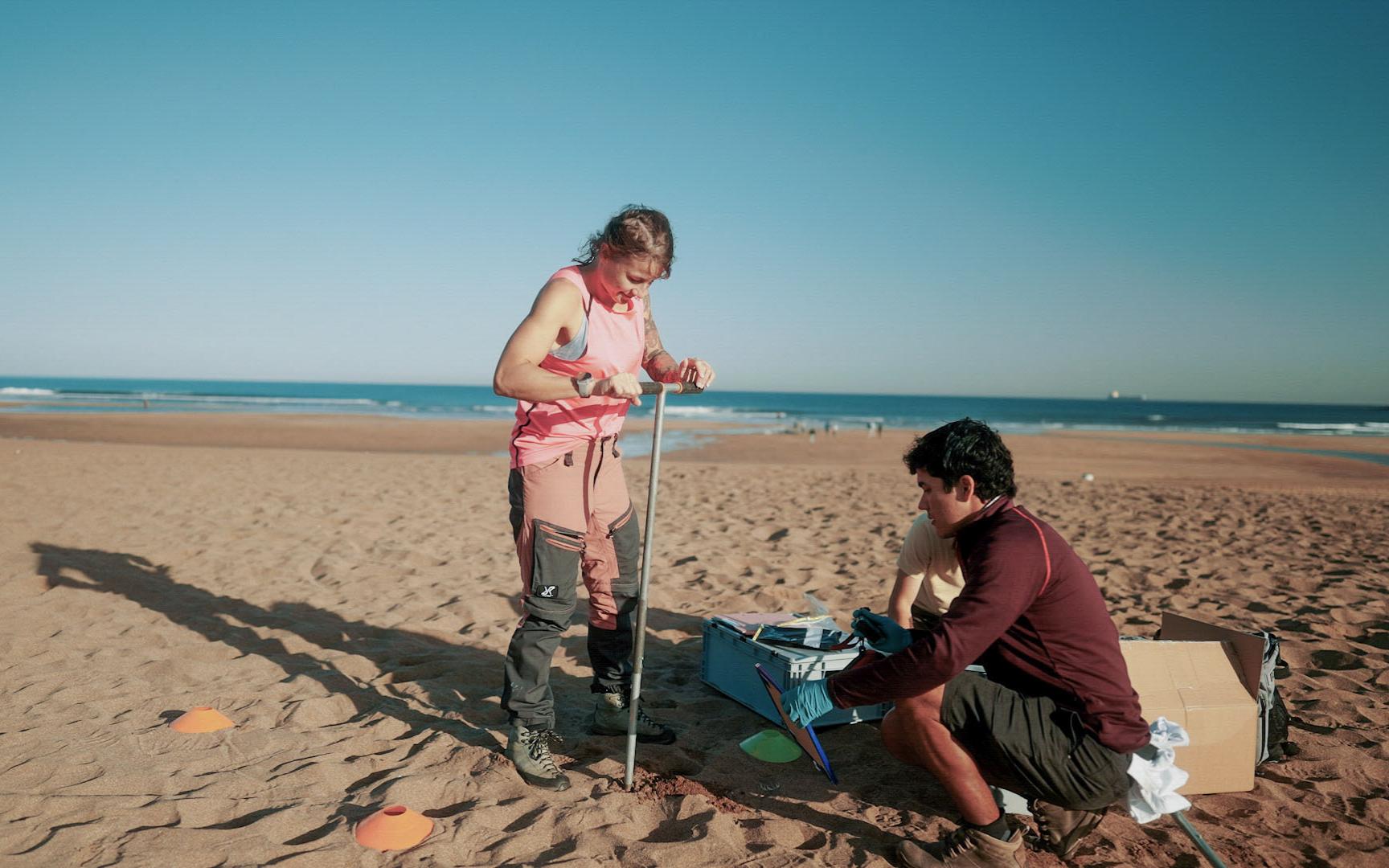 Drei Wissenschaftler: innen entnehmen Proben am Strand