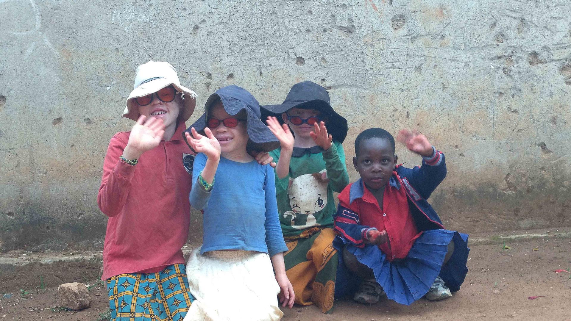 Eine Gruppe von Kindern winkt der Betrachterperspektive zu
