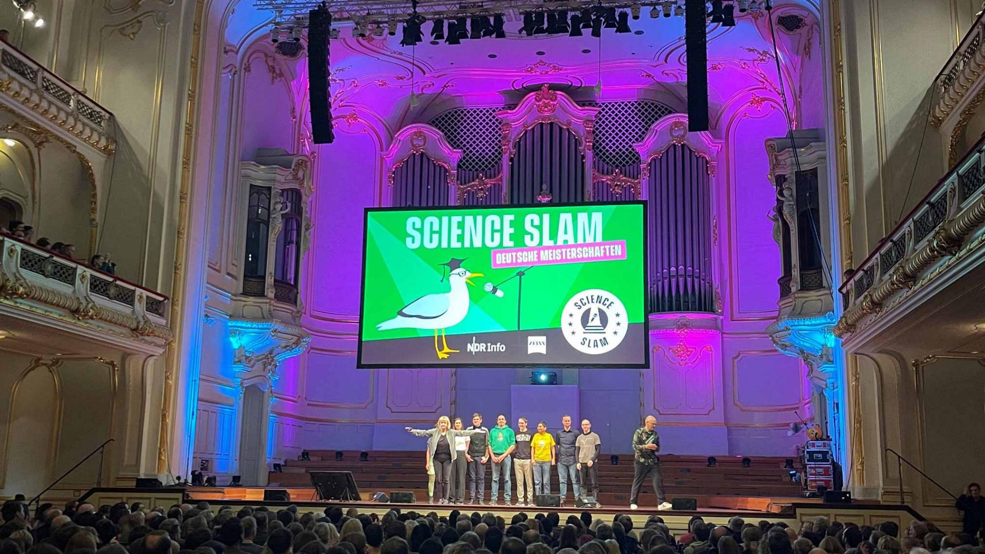 Siegerinnen und Sieger stehen auf der Bühne des Science Slam