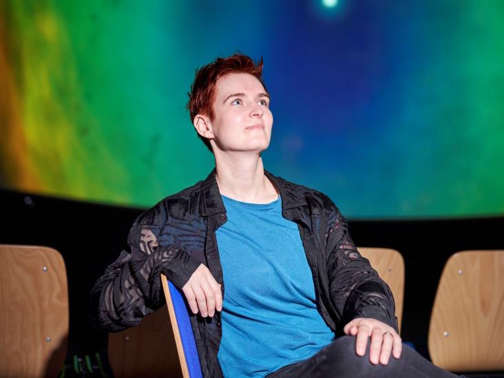 Louisa Pragst sitzt in einem Planetarien-Vorführraum.