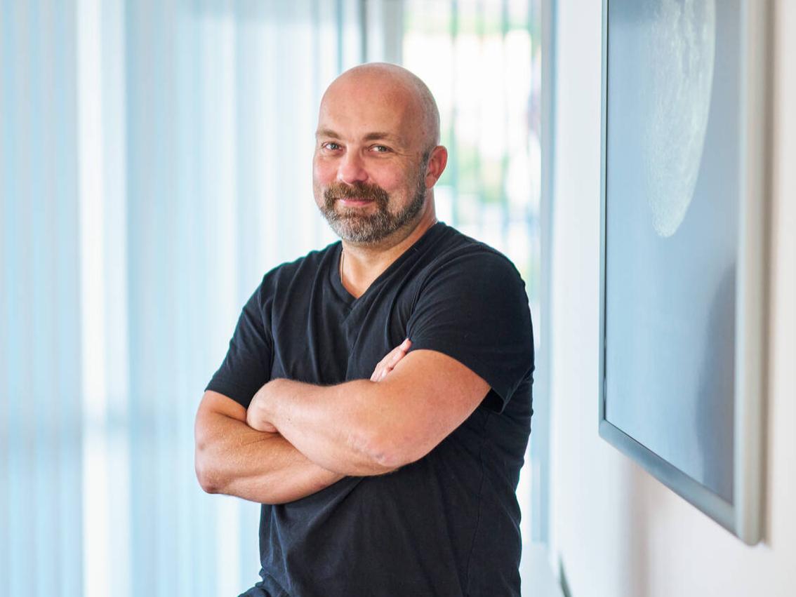 Dr. Andreas Schmidt steht im Büro bei ZEISS.