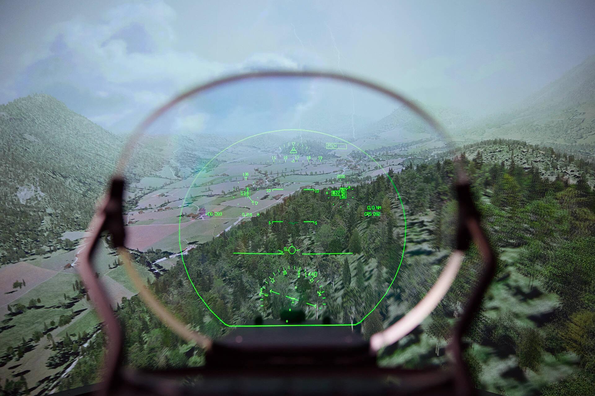 Blick durch ein AR Head-Up-Display-Modell auf eine wolkige Berglandschaft aus einem Flugzeug heraus.