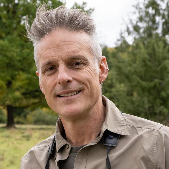 Porträtbild von Nick Baker. Es schaut direkt in die Kamera und lächelt freundlich.