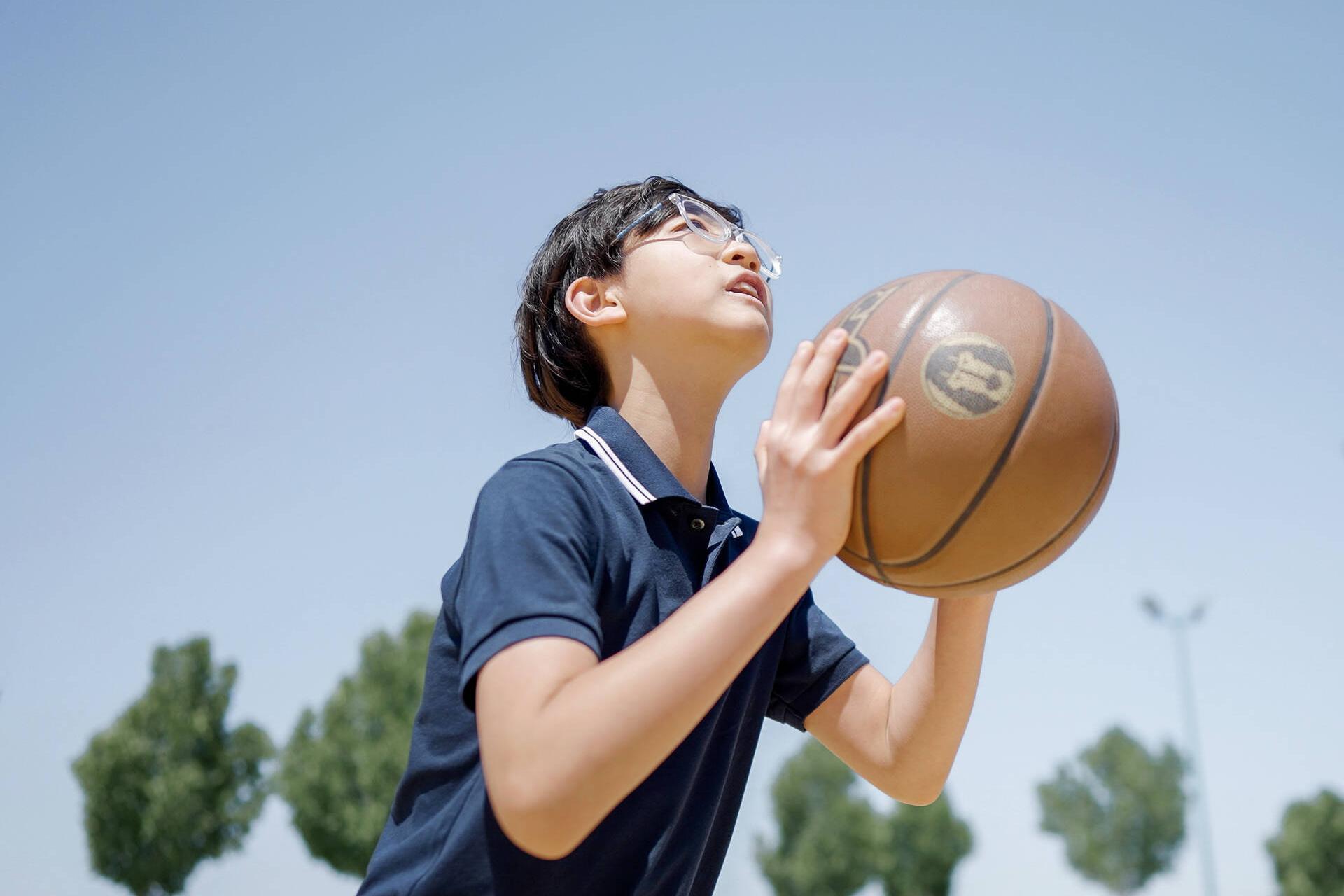 Aidan Zhong zielt auf den Korb eines Basketballfeldes im Freien