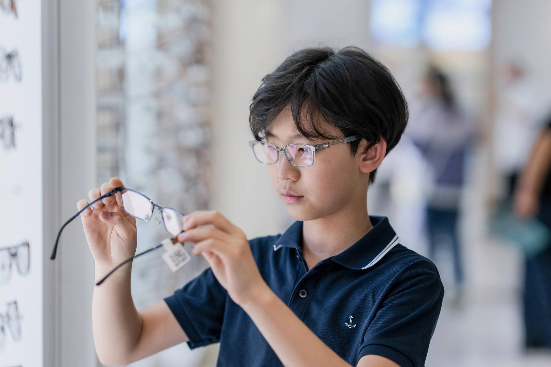 Aidan Zhong schaut sich eine neue Brille an