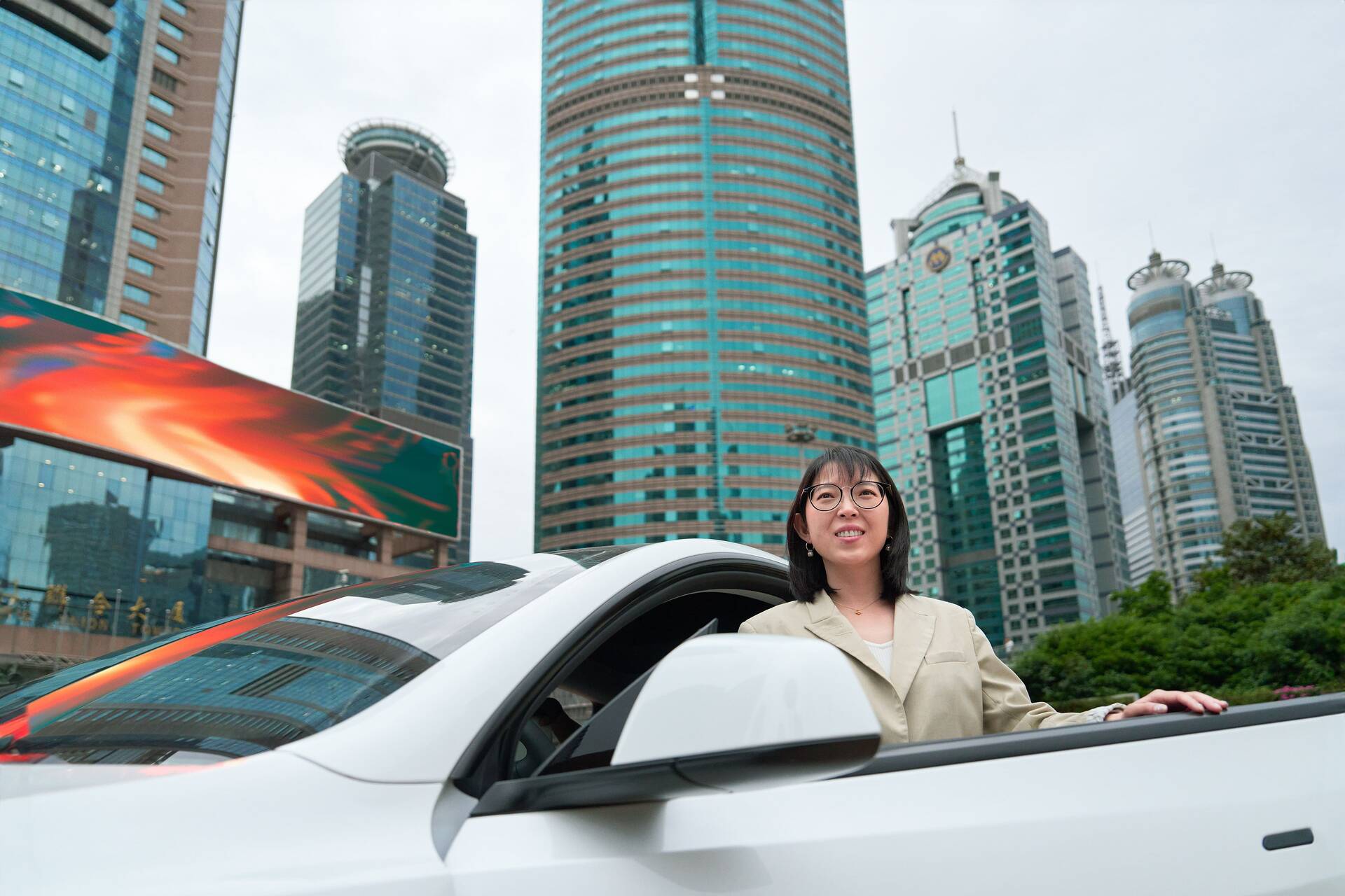 Yuqing Bai vor ihrem Auto in Shanghai
