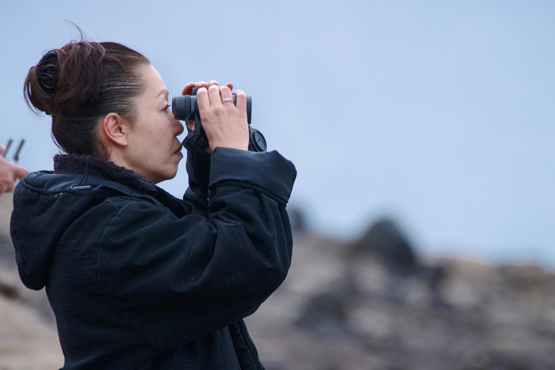 Yuko Tajima schaut durch ein ZEISS Fernglas