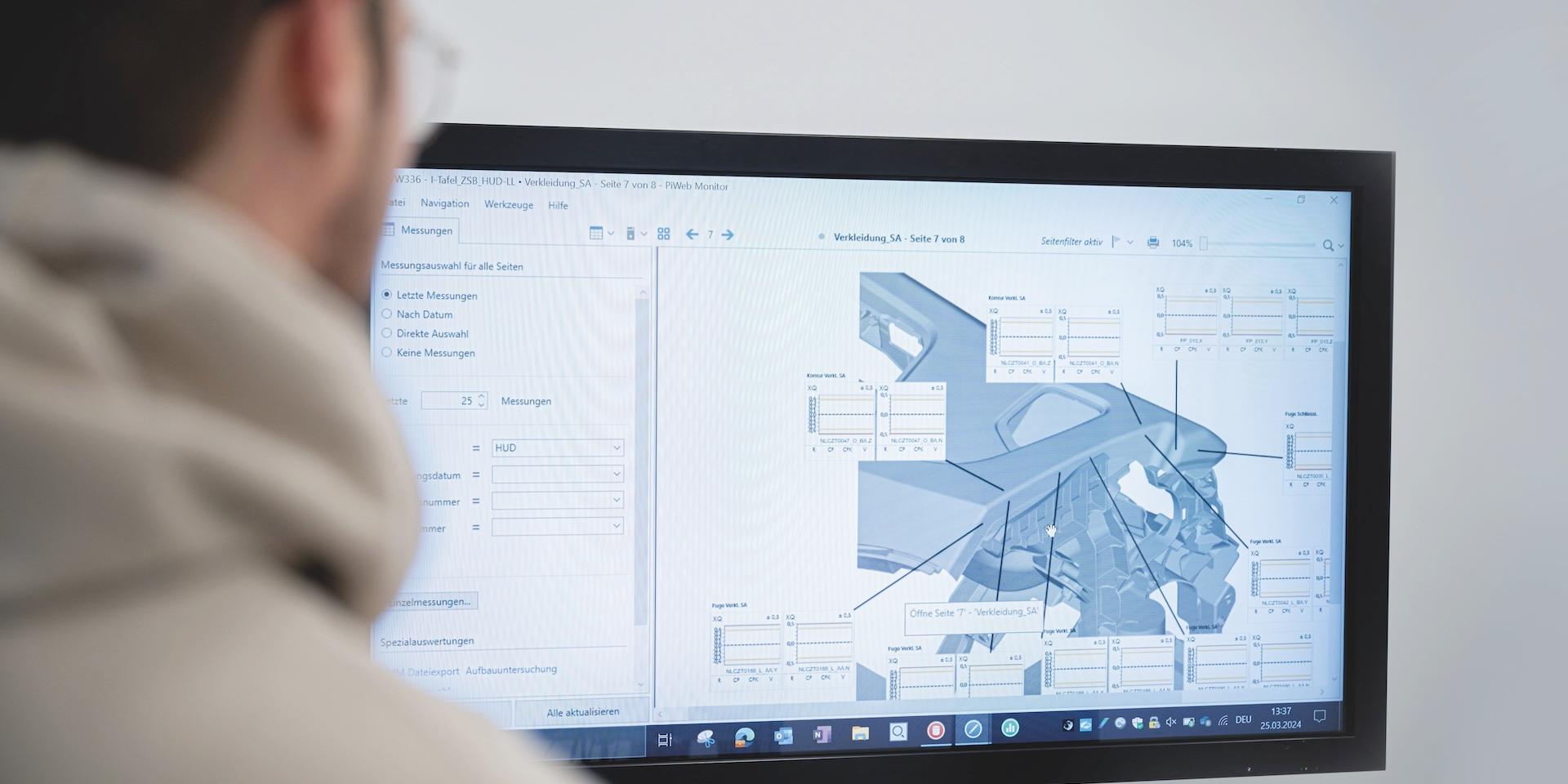 Eine Person schaut auf einen großen Bildschirm, auf dem abstrakte visuelle Daten in einer dunklen Umgebung angezeigt werden