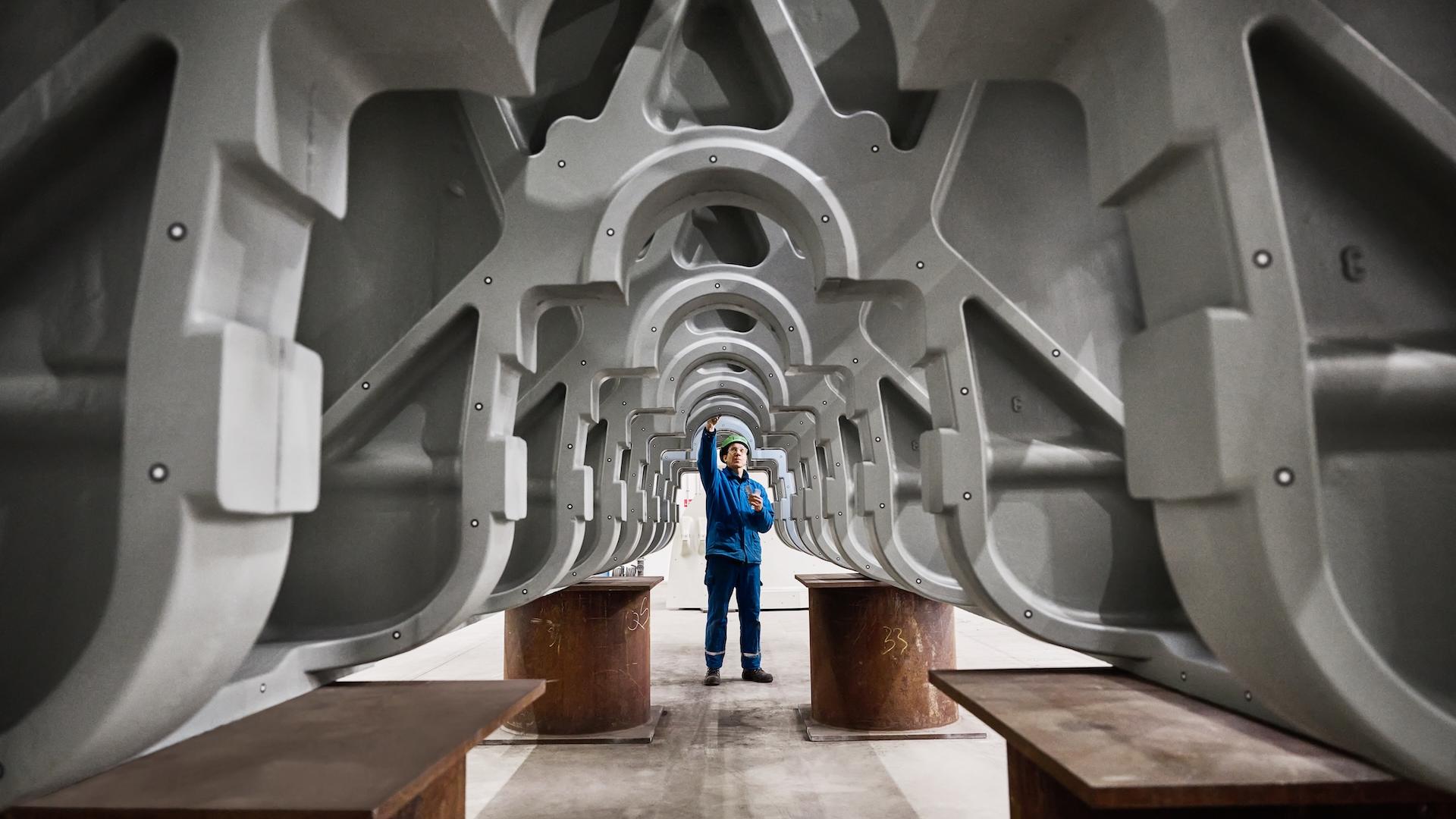 Ingenieur, der ein riesiges Metallbauteil prüft