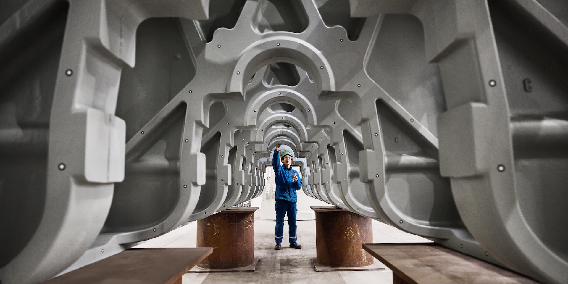 Ingenieur, der ein riesiges Metallbauteil prüft