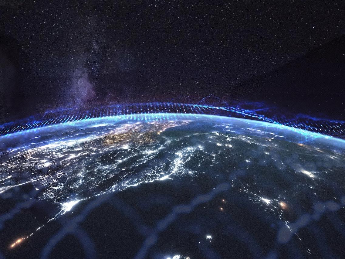 View of Earth from space at night with illuminated cities and a digital grid overlay, representing advanced ZEISS technology.