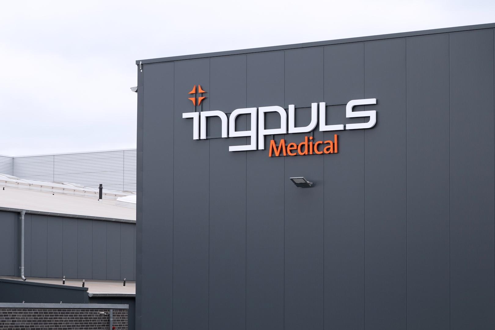 Außenansicht eines modernen Industriegebäudes mit dem Logo „ingpuls Medical“ auf der dunkelgrauen Fassade.