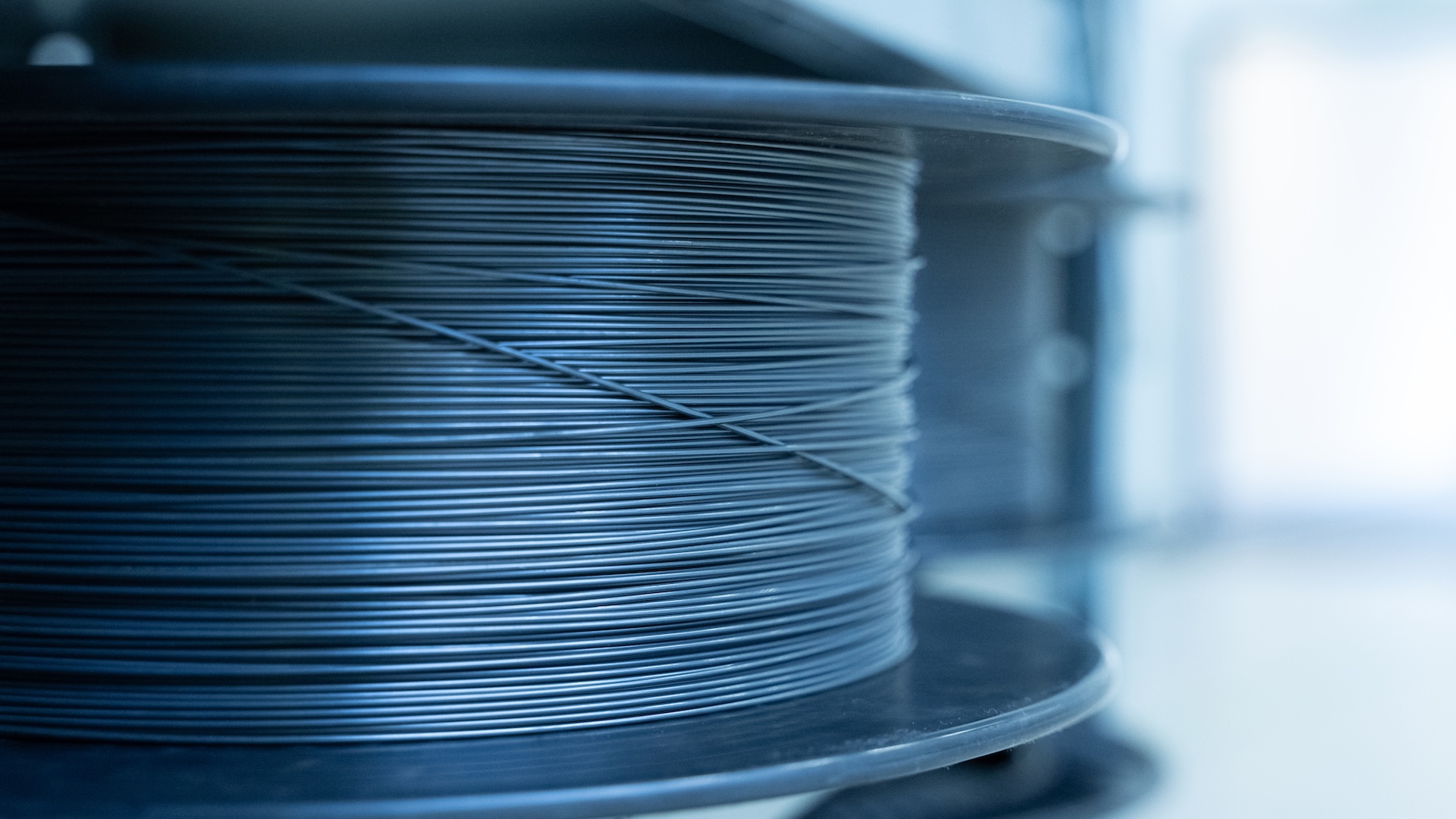 Nahaufnahme einer Spule, die in einer sauberen, industriellen Umgebung bei ZEISS fest mit ultradünnem Nitinol-Draht umwickelt ist.