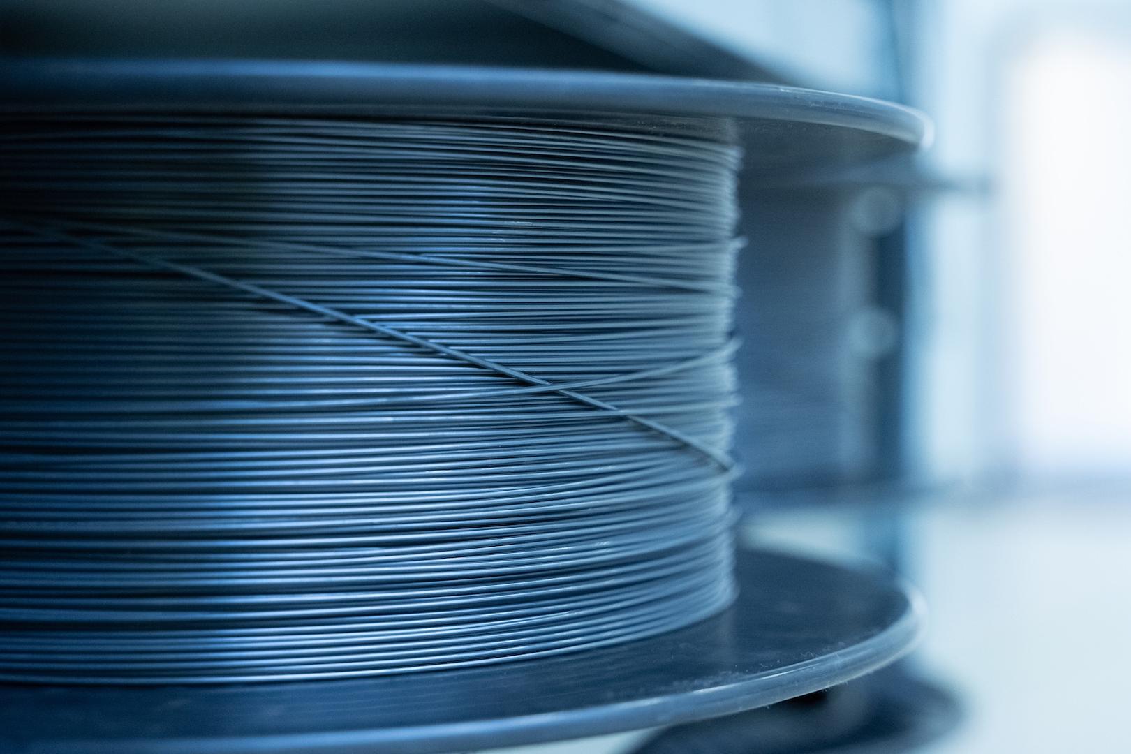 Nahaufnahme einer fest mit dünnem Metalldraht umwickelten Spule in einer sauberen, industriellen Umgebung bei ZEISS.