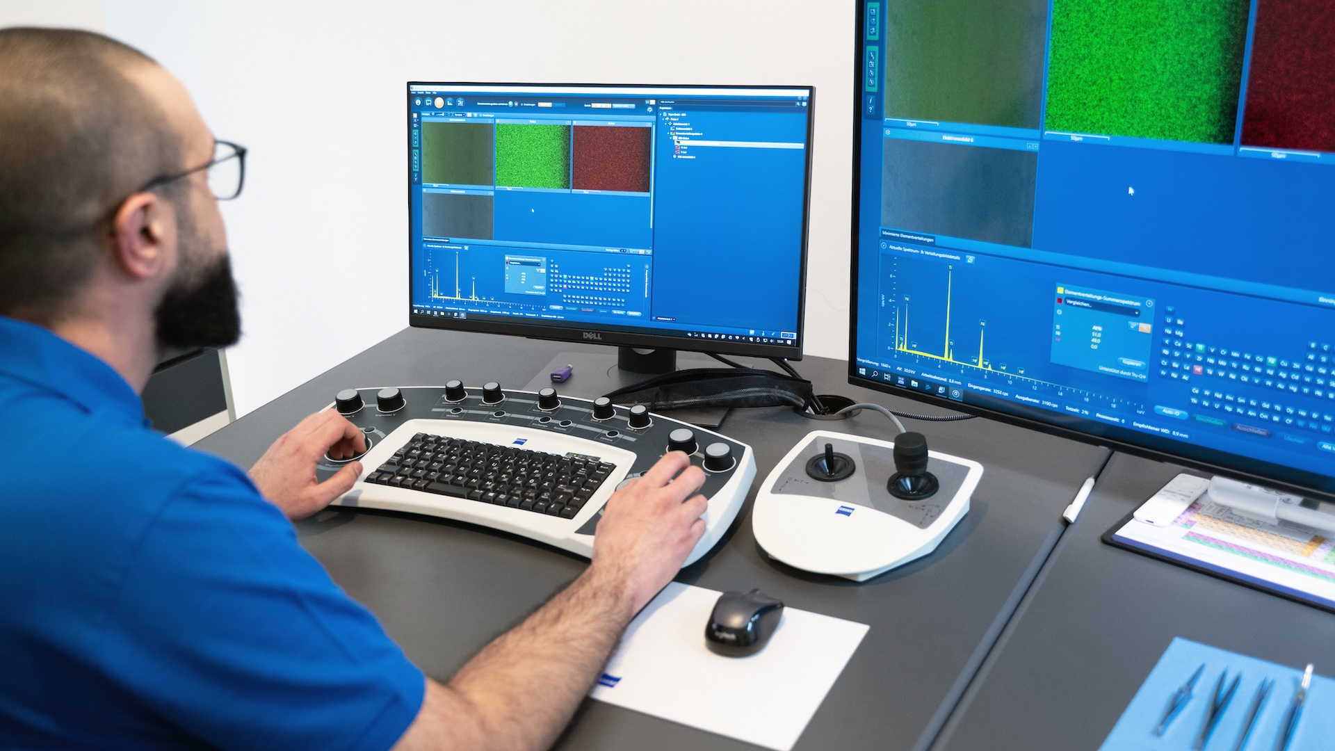 Ein Techniker bedient eine ZEISS Imaging-Software auf zwei Monitoren über eine spezielle Steuerkonsole in einer Laborumgebung.