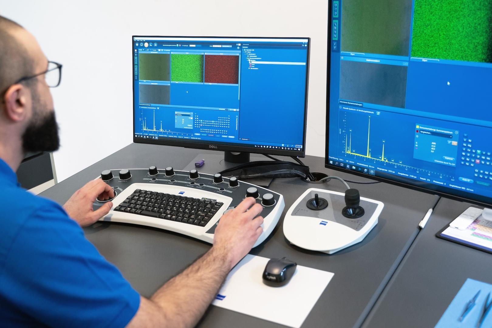 Ein Techniker bedient eine ZEISS Imaging-Software auf zwei Monitoren über eine spezielle Steuerkonsole in einer Laborumgebung.