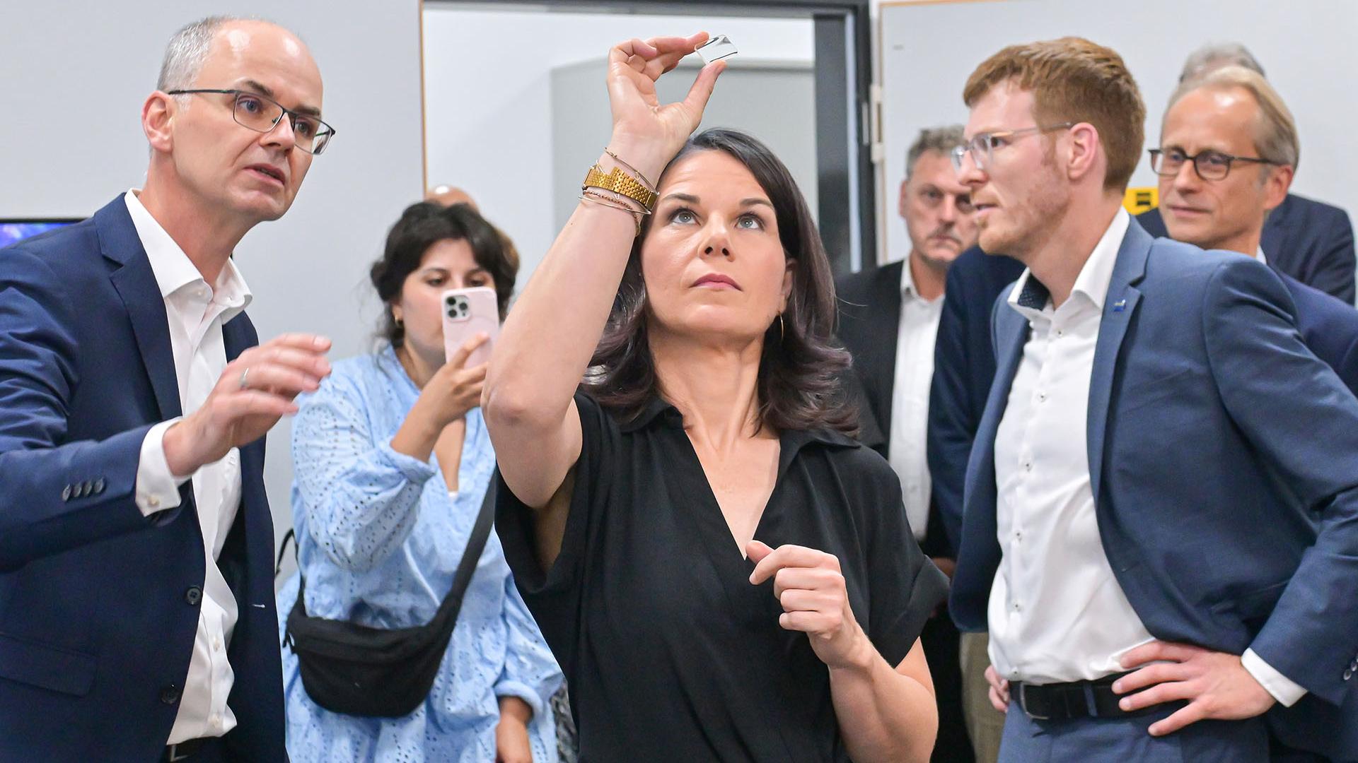 Dr. Thomas Kalkbrenner, Mikroskopspezialist bei ZEISS (links) stellte der Außenministerin gemeinsam mit Dr. Michael Albiez, Geschäftsführer der Carl Zeiss Microscopy GmbH (rechts), das mit dem Deutschen Zukunftspreis 2022 ausgezeichnete Mikroskopsystem ZEISS Lattice Lightsheet 7 vor.