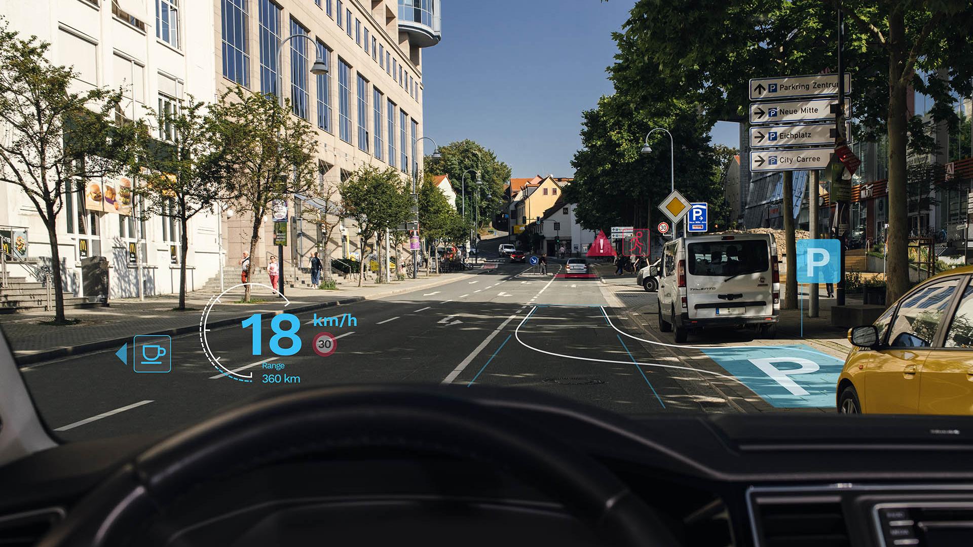 Holografische Augmented Reality Head-Up-Displays auf Basis der ZEISS „Multifunctional Smart Glass“-Technologie projizieren wichtige Infos, ohne dass Autofahrer und Autofahrerinnen den Blick von der Straße wenden müssen.