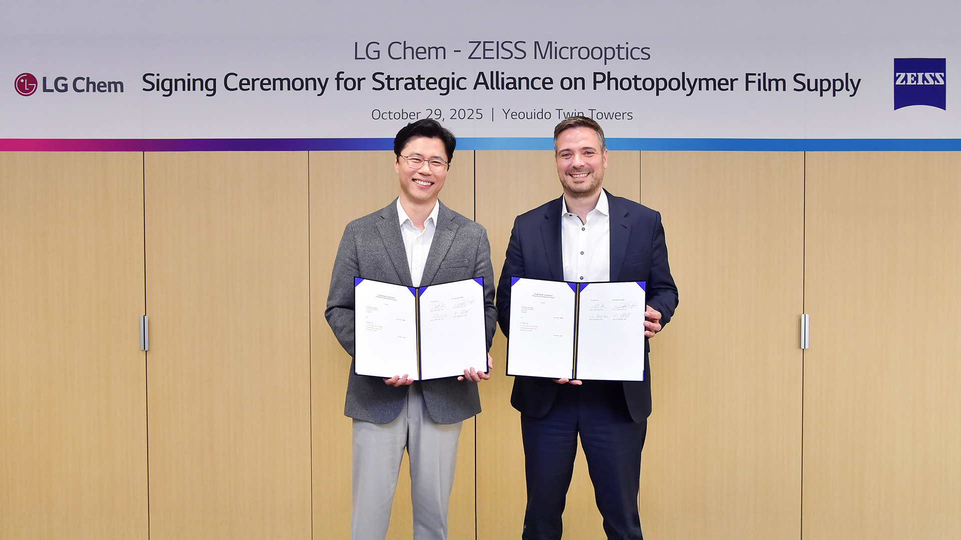 In LG Chem´s Yeouido Twin Towers stehen Ko Kyung-deok, Vice President and Head of Electronics Materials Business Unit bei LG Chem (links), und Stephan Höfer, Senior Vice President and Head of Business Development and Marketing bei ZEISS Microoptics (rechts), für ein Erinnerungsfoto nach der Unterzeichnung einer strategischen Partnerschaft für Photopolymere zusammen.
