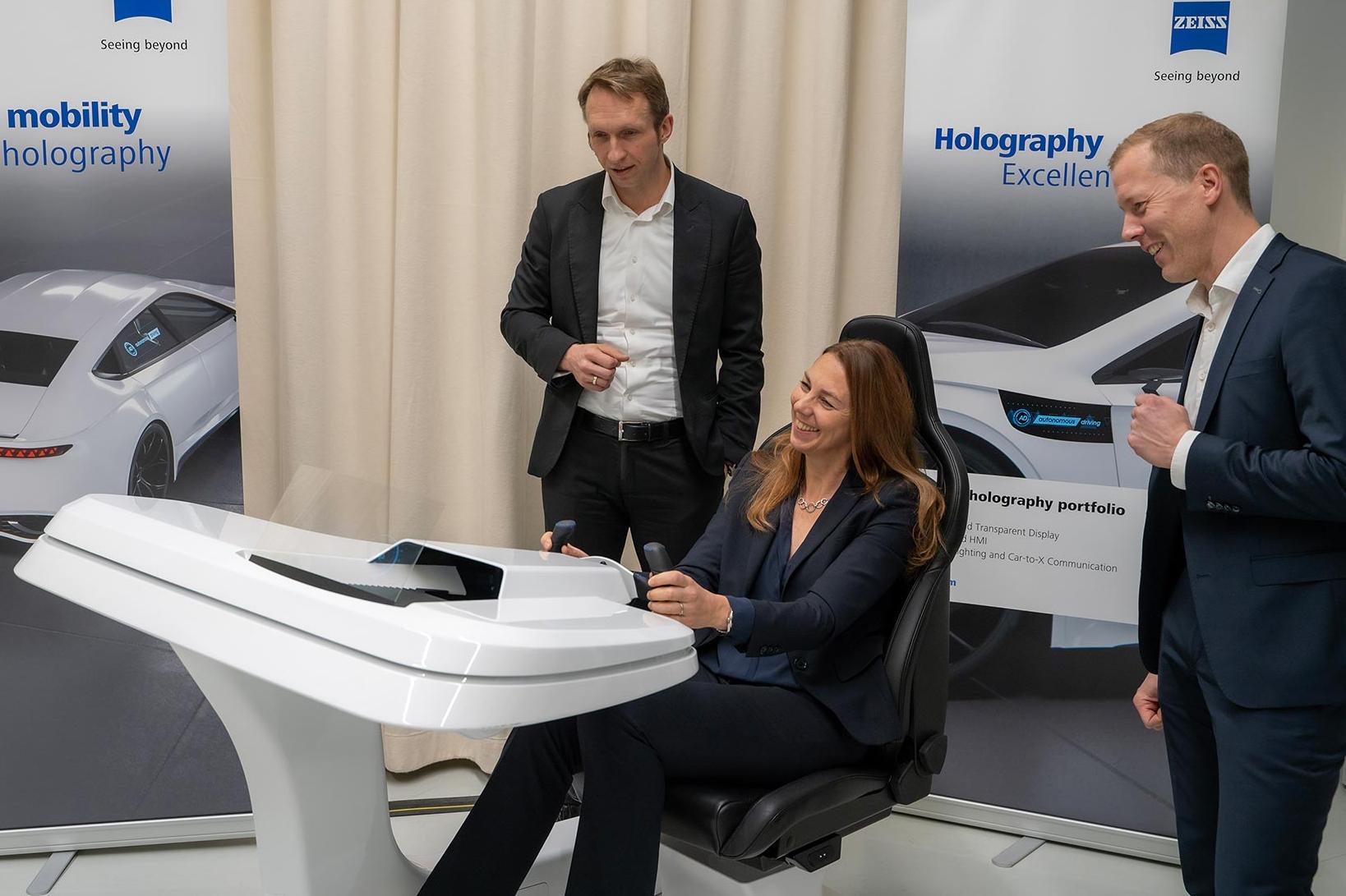 André Kutz (Head of ZEISS Photonics and Optics), Dr. Ingrid Sebald (Board Member Technology, tesa) und Dr. Roman Kleindienst (Head of ZEISS Microoptics) (v.l.) am Holographic Transparent Display für Automotive-Anwendungen.