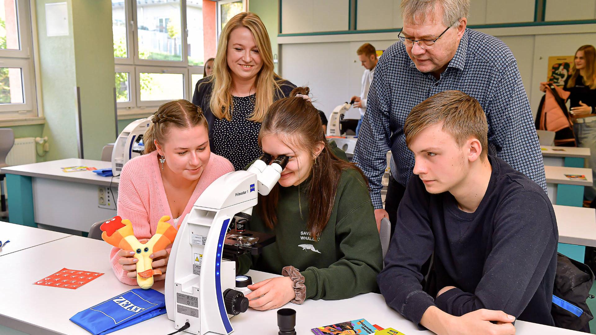 Ksenia Matusevich, Isabel Rößler und Jan Pöhlmann (vorn v.l.) können mit den ZEISS Mikroskopen grundlegende mikroskopische Techniken sowie medizinisch-biologische Routinearbeiten unter realitätsnahen Bedingungen erlernen. Die Fachlehrerin für Biologie an der SBBS Dr. Anne Beer und ZEISS Mikroskopspezialist Manfred Barth (hinten v.l.) bei der offiziellen Inbetriebnahme der Mikroskope.