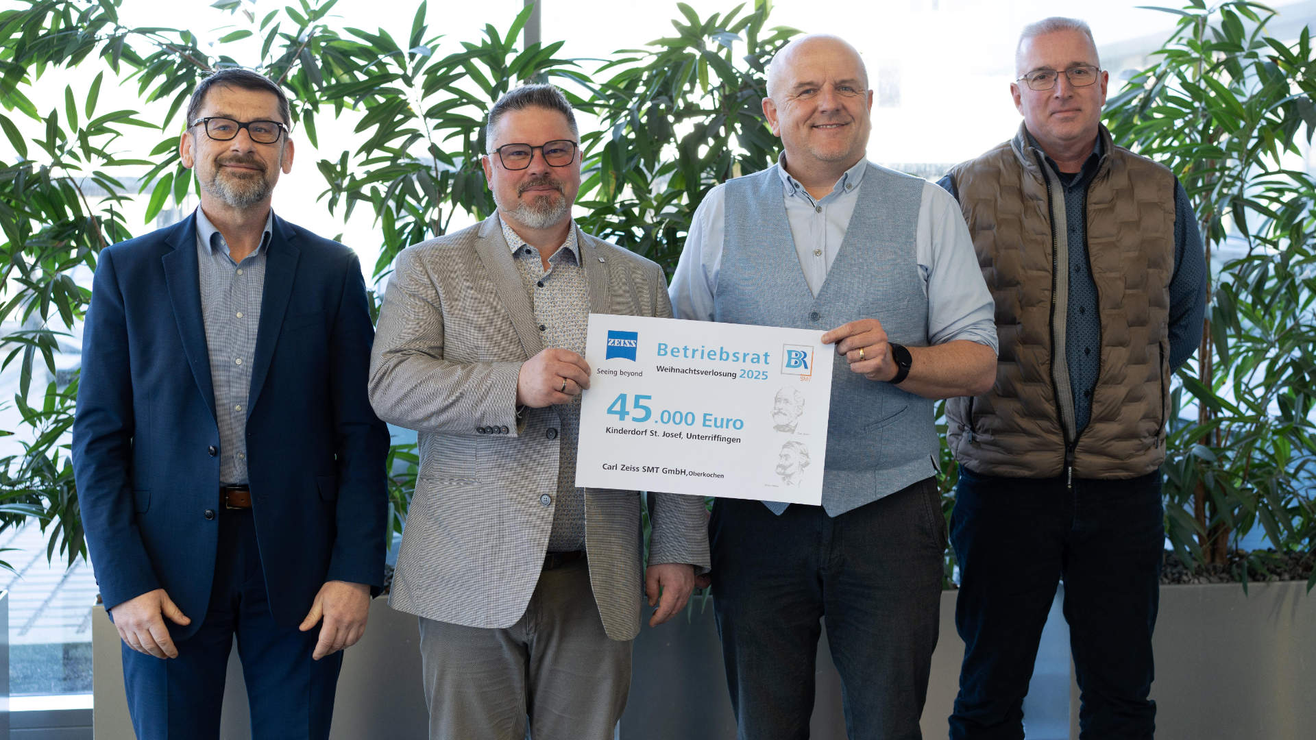 Vier Männer halten einen Spendenscheck.