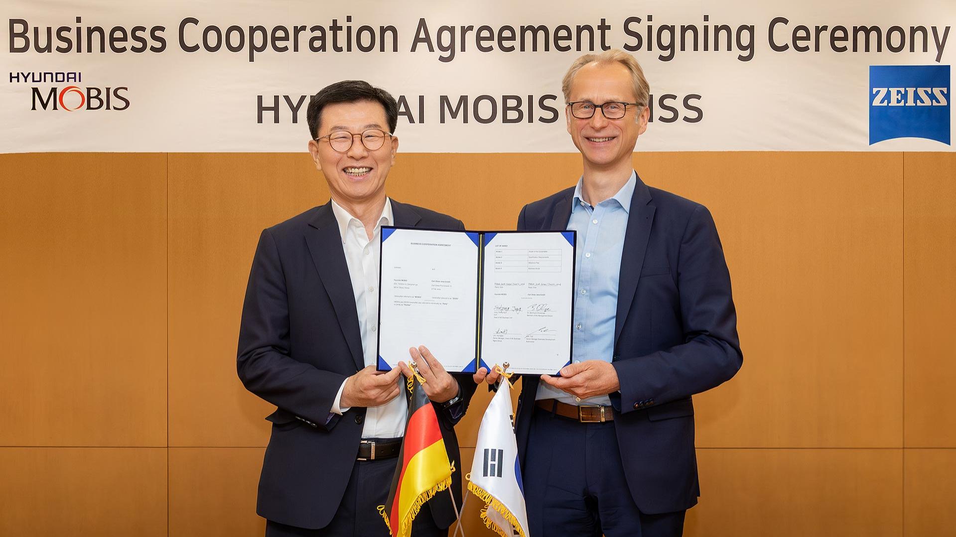 Dr. Bernhard Ohnesorge, Mitglied der Geschäftsleitung der Shared Production Unit bei ZEISS (rechts) und Jung Soo-kyung, Executive Vice President und Leiter der Automotive Electronics Business Unit bei Hyundai Mobis (links), bei der Unterzeichnung.