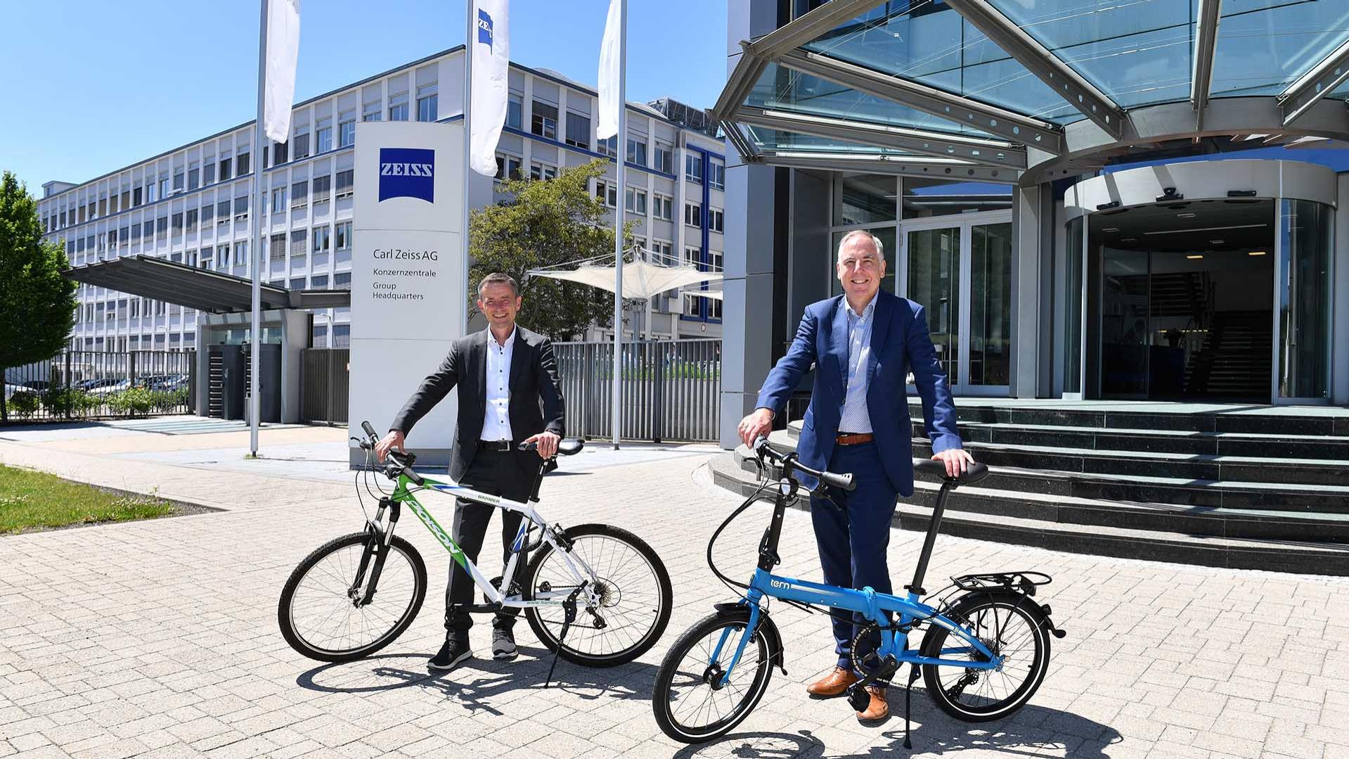 Kai Nar, Regionalgeschäftsführer der BARMER in Aalen und Franz Donner, Leitung Corporate Human Resources der ZEISS Gruppe, freuen sich über den Start der bundesweite Radbonus-Challenge. Das blaue Faltrad, ist einer der Hauptpreise, die unter den Teilnehmenden vergeben werden.
