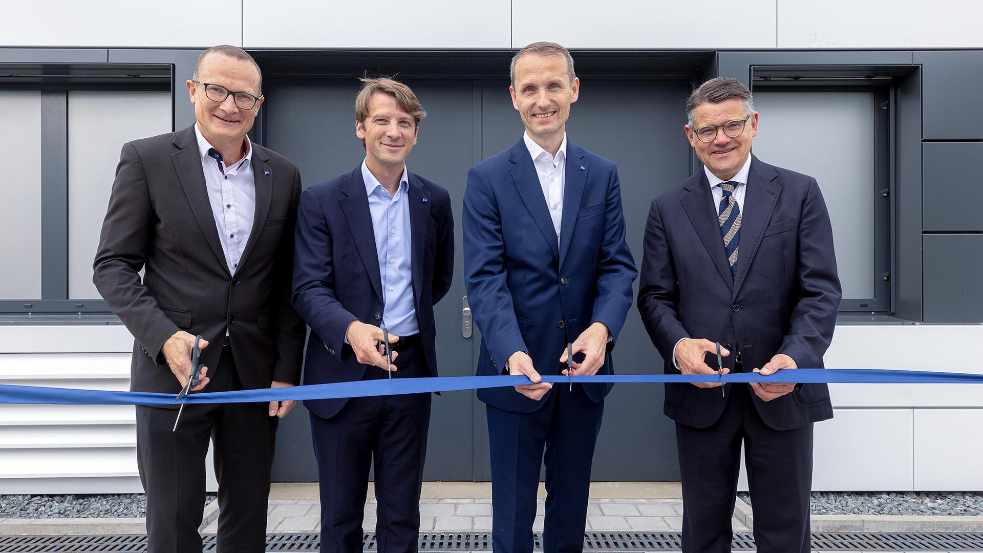 Das Bild zeigt vier Personen bei der feierlichen Eröffnung der neuen Reinraumfläche von ZEISS Semiconductor Manufacturing Technology am hessischen Standort Roßdorf. Dort werden hochpräzise Maskenreparatursysteme entwickelt.