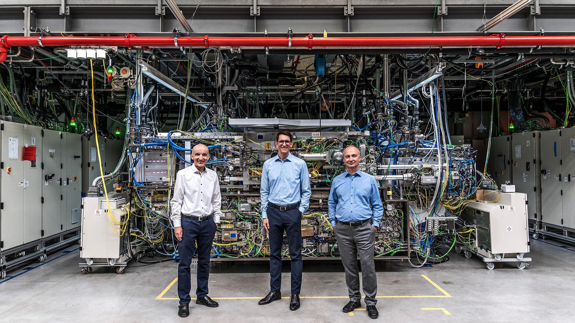 Dr. Sergiy Yulin, Dr. Peter Kürz und Dr. Michael Kösters stehen vor dem weltweit stärksten gepulsten Industrielaser