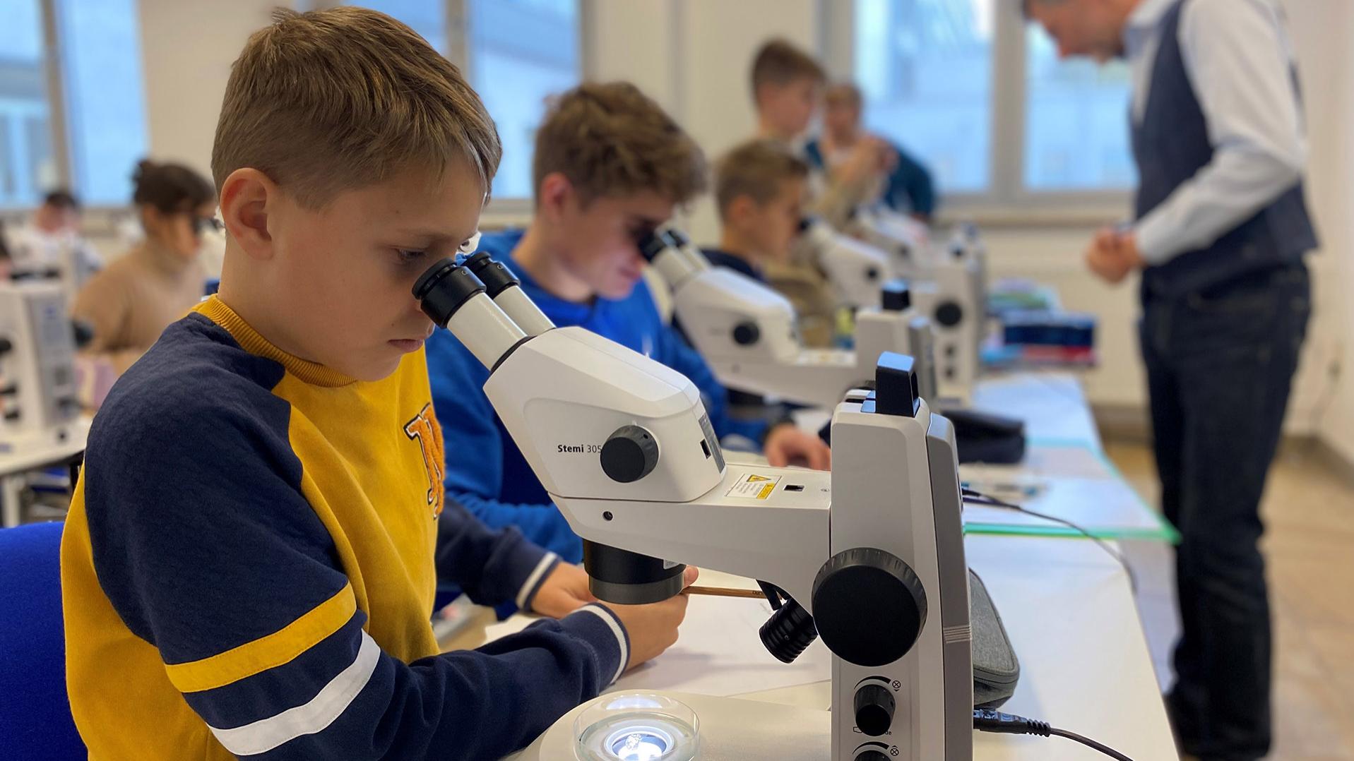 Schüler des Lyonel-Feininger-Gymnasiums beim Mikroskopieren an einem ZEISS Stemi 305 Mikroskop.
