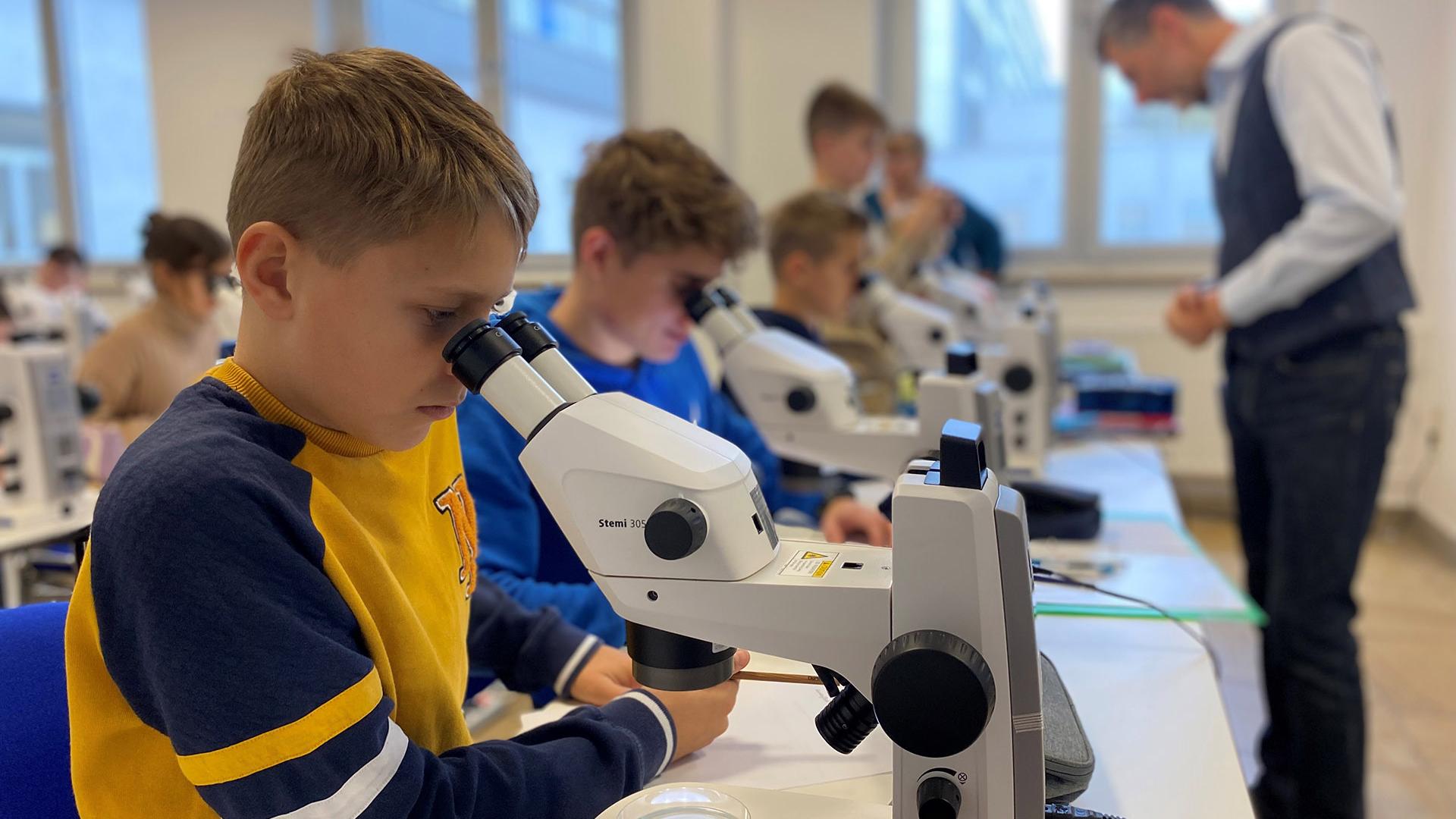 Schüler des Lyonel-Feininger-Gymnasiums beim Mikroskopieren an einem ZEISS Stemi 305 Mikroskop.