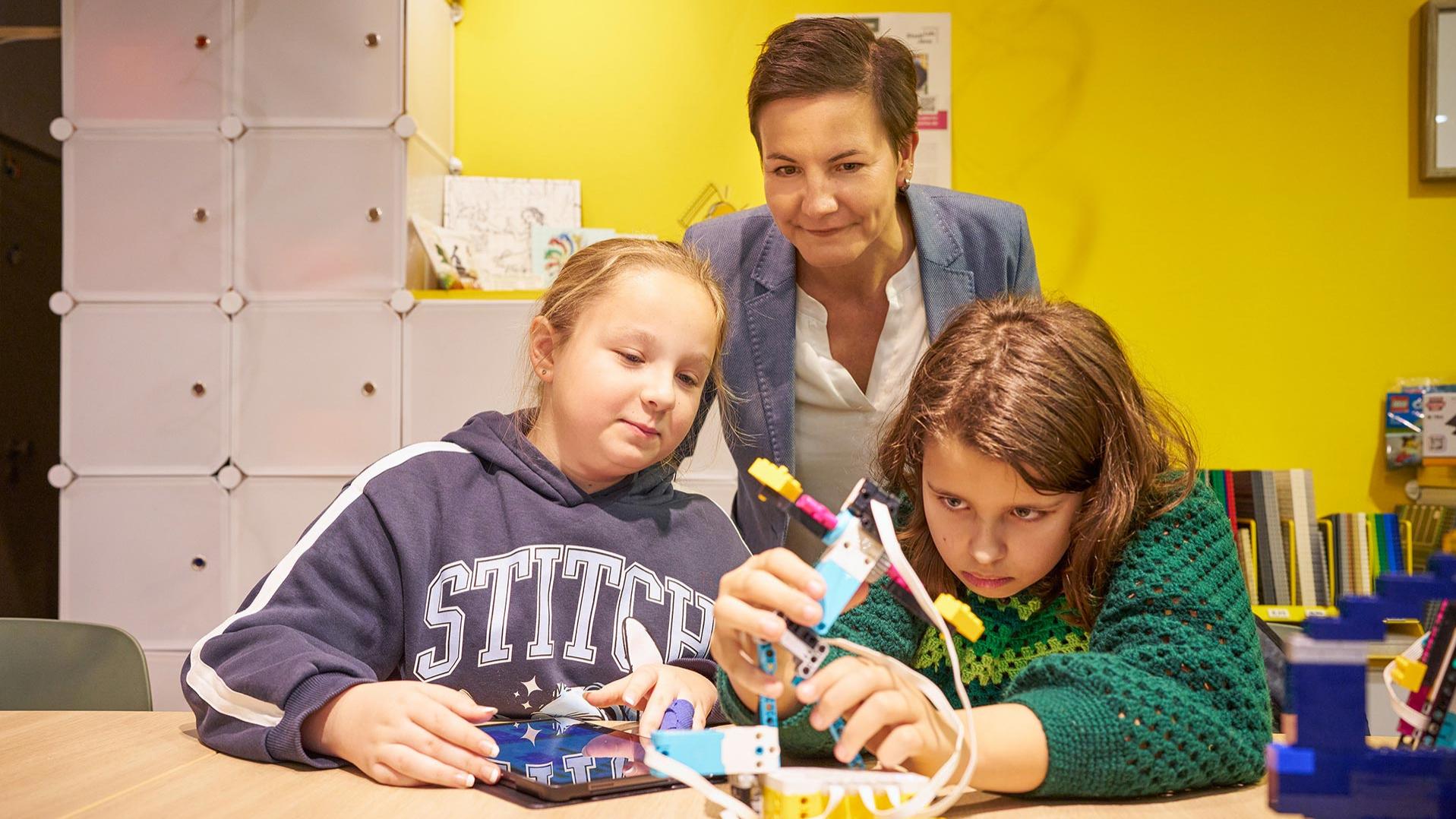 Luise (links) und Eve (rechts) aus der Robotik-AG für Mädchen zeigen Nadine Cunäus (Mitte), Personalleiterin der Carl Zeiss Jena GmbH und Vorstandsmitglied von witelo e. V., ihren selbstgebauten Roboter.