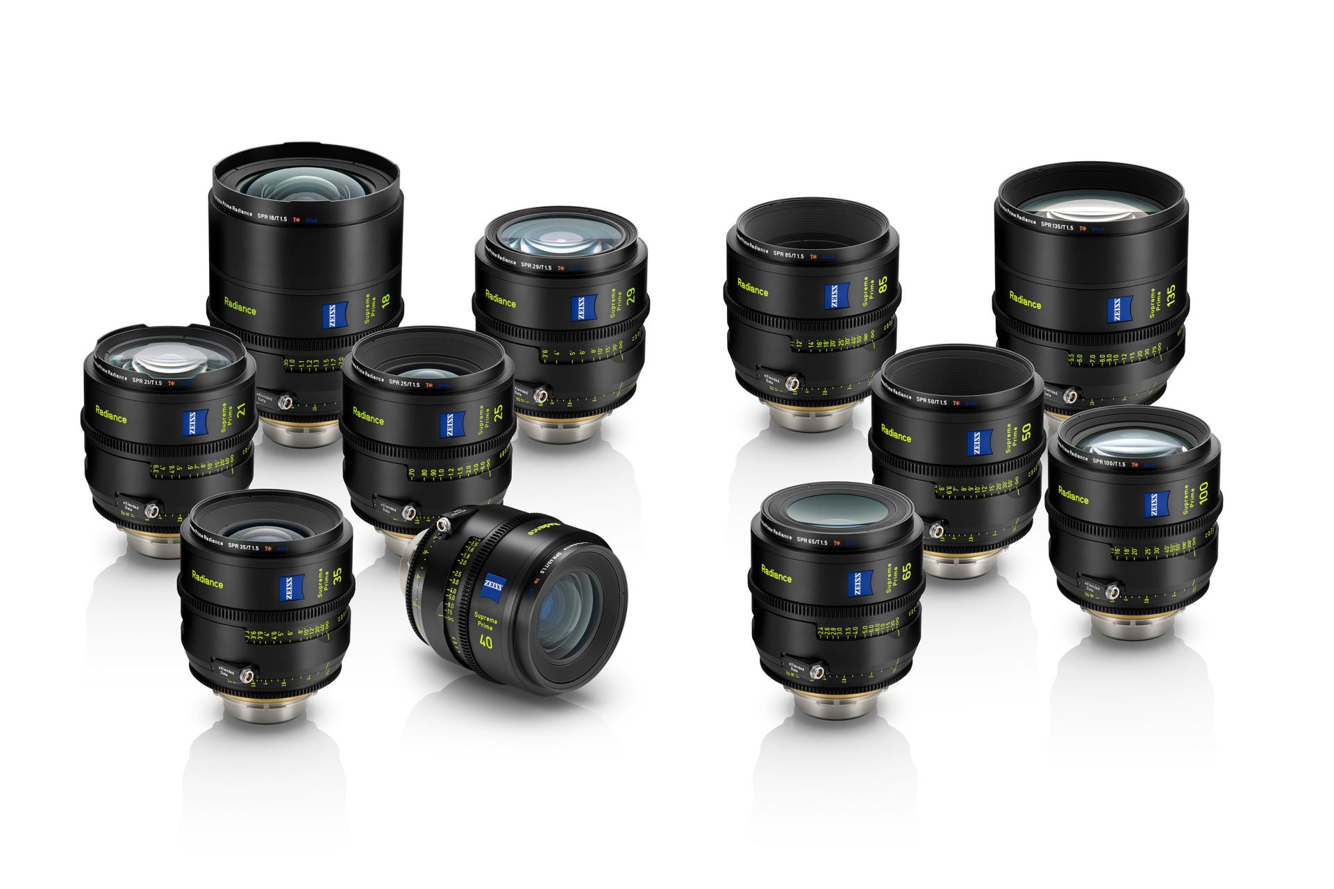 Eine Sammlung professioneller ZEISS-Kameraobjektive, angeordnet auf einer weißen reflektierenden Oberfläche.