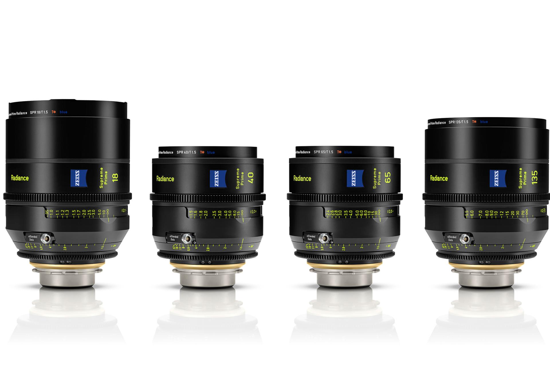 Vier ZEISS Supreme Prime-Kameraobjektive sind aufrecht in einer Reihe auf einem weißen Hintergrund angeordnet.
