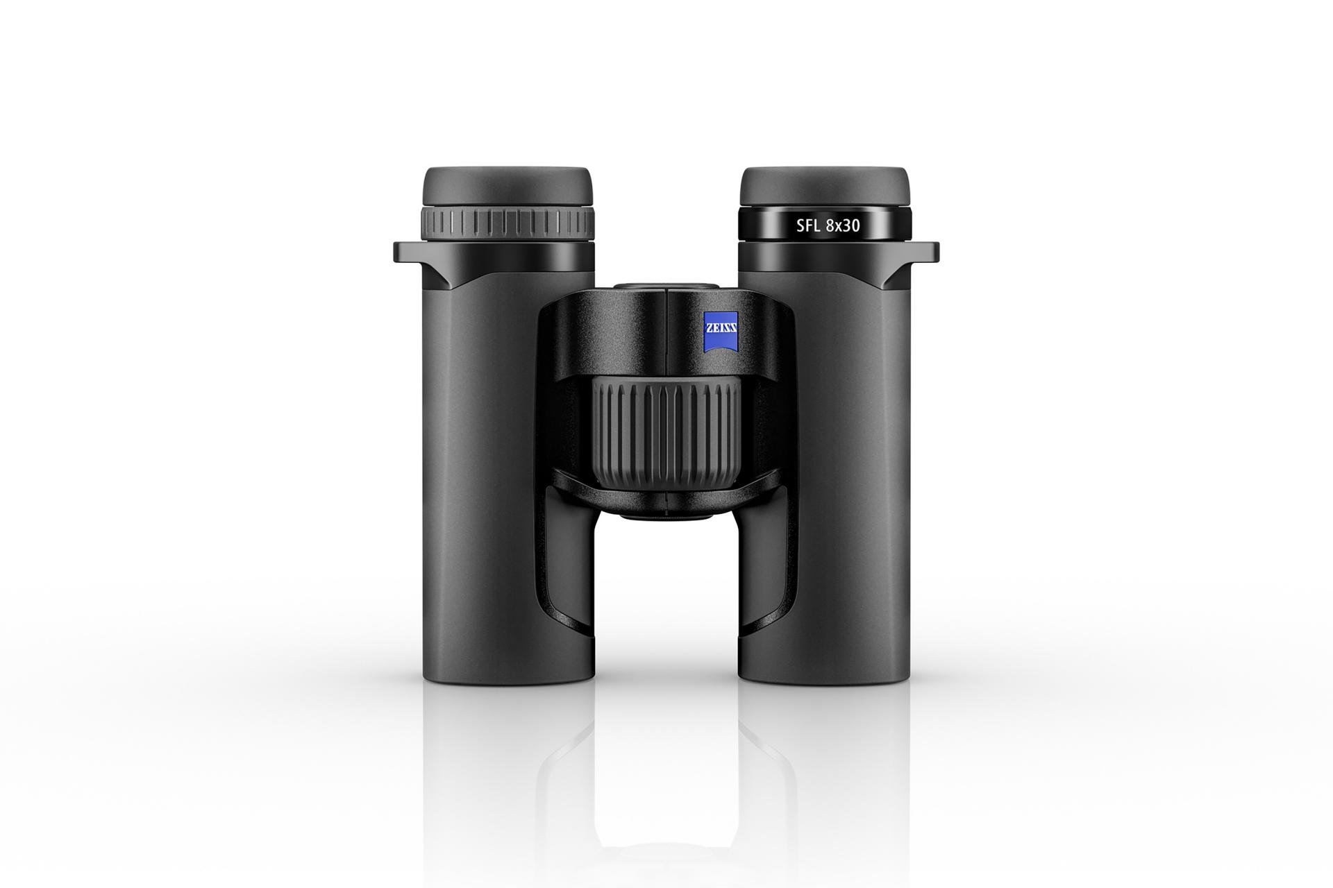 Schwarzes Fernglas ZEISS SFL 8x30 mit zentralem Fokussierrad, aufrecht stehend auf einer weißen reflektierenden Oberfläche abgebildet.