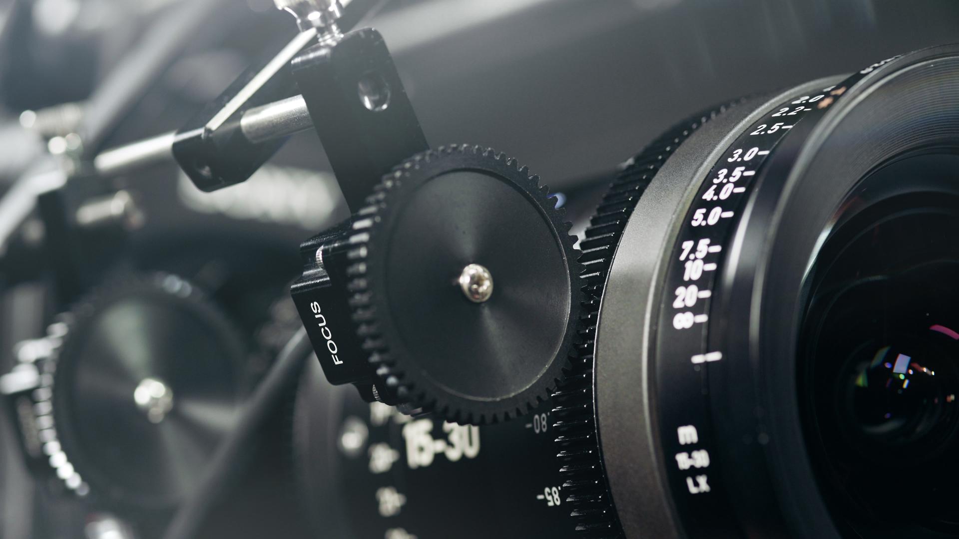 Nahaufnahme eines professionellen Kinokameraobjektivs mit Fokus- und Zoomsteuerungsringen, das das ZEISS-Branding und die Präzisionstechnik zeigt.