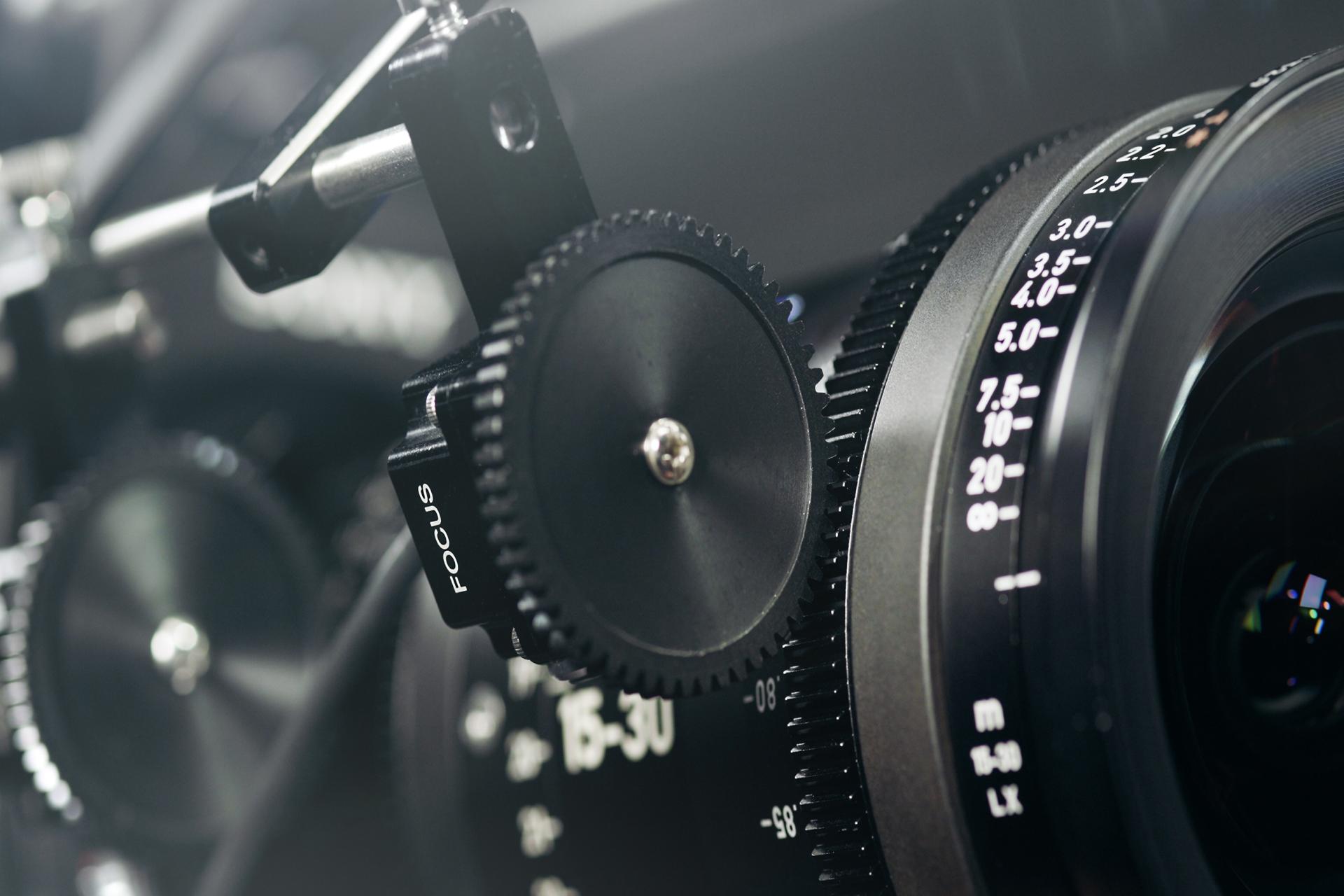 Nahaufnahme eines professionellen Kinokameraobjektivs mit Fokus- und Zoomsteuerungsringen, das das ZEISS-Branding und die Präzisionstechnik zeigt.