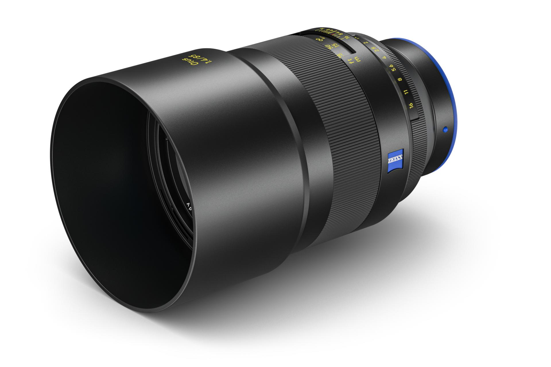 Schwarzes ZEISS-Kameraobjektiv mit sichtbaren Fokus- und Blendenringen, blauem ZEISS-Logo und aufgesetzter Gegenlichtblende.