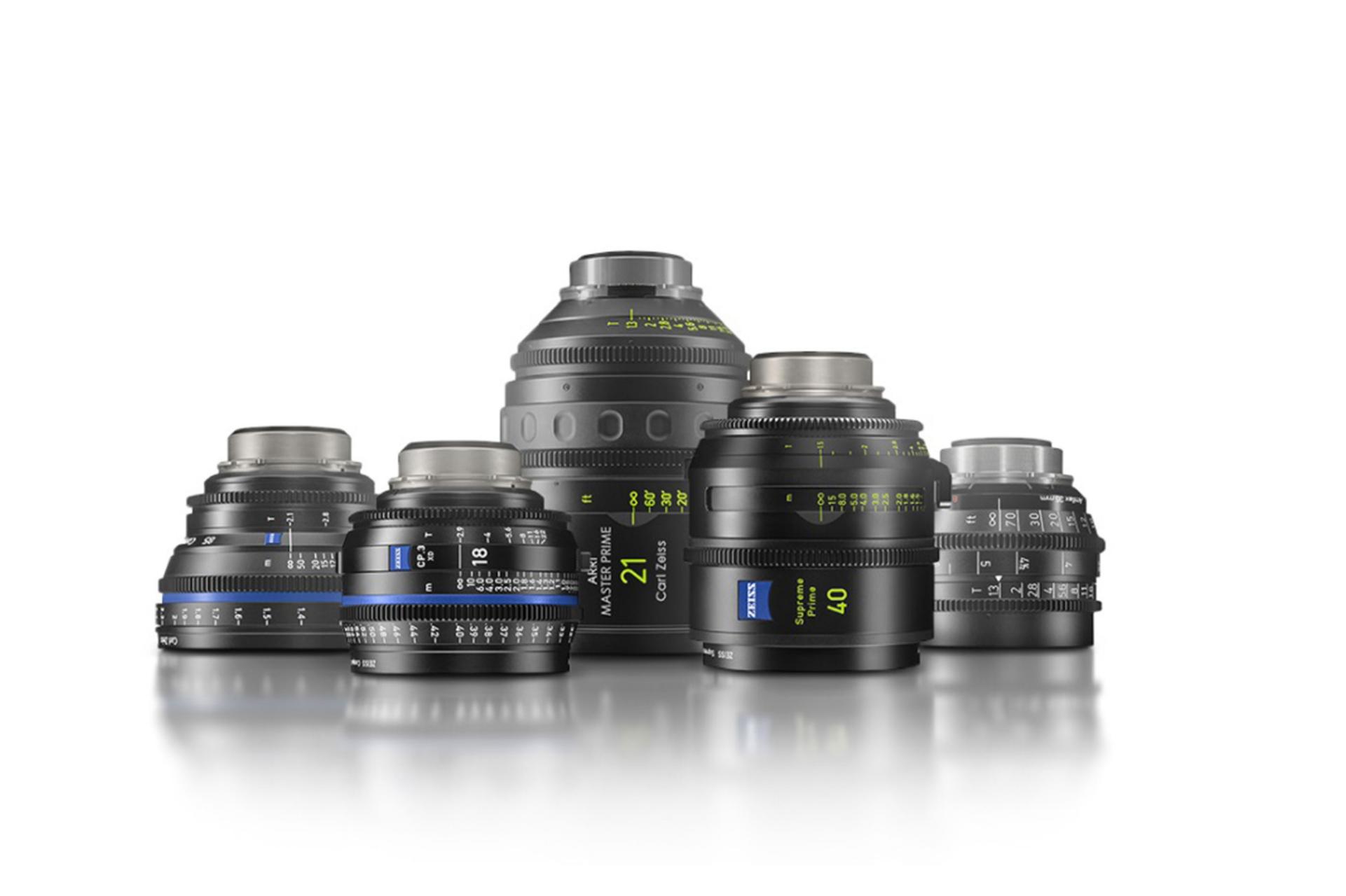 A professional lineup of high-quality ZEISS cinema lenses, including ZEISS Supreme Prime and Compact Prime CP.3 series, arranged on a reflective surface.