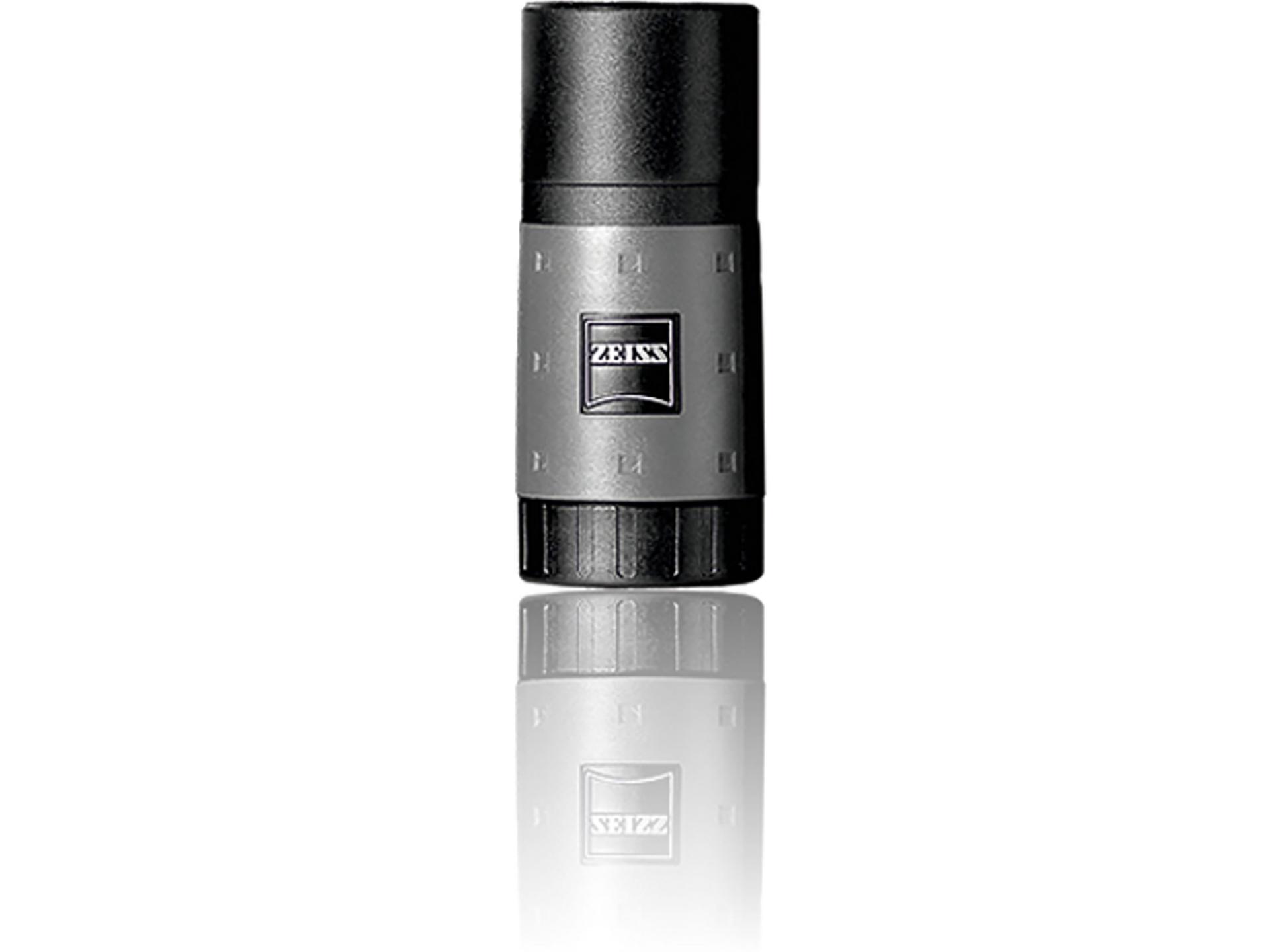 A compact, cylindrical ZEISS optical device with a black top and metallic body, featuring the ZEISS logo on the front, shown against a white background with a subtle reflection.