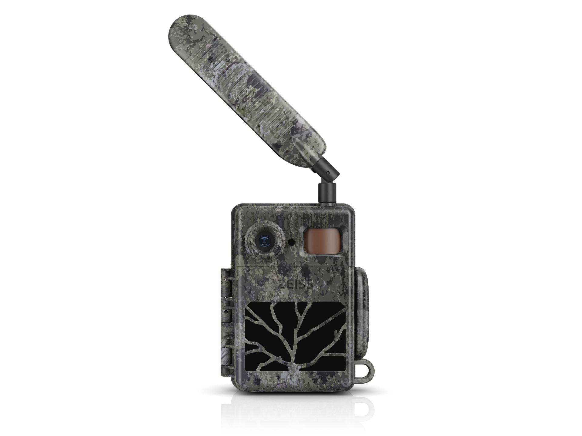 Camouflaged ZEISS trail camera with an external antenna, lens, and display screen, designed for outdoor wildlife monitoring.