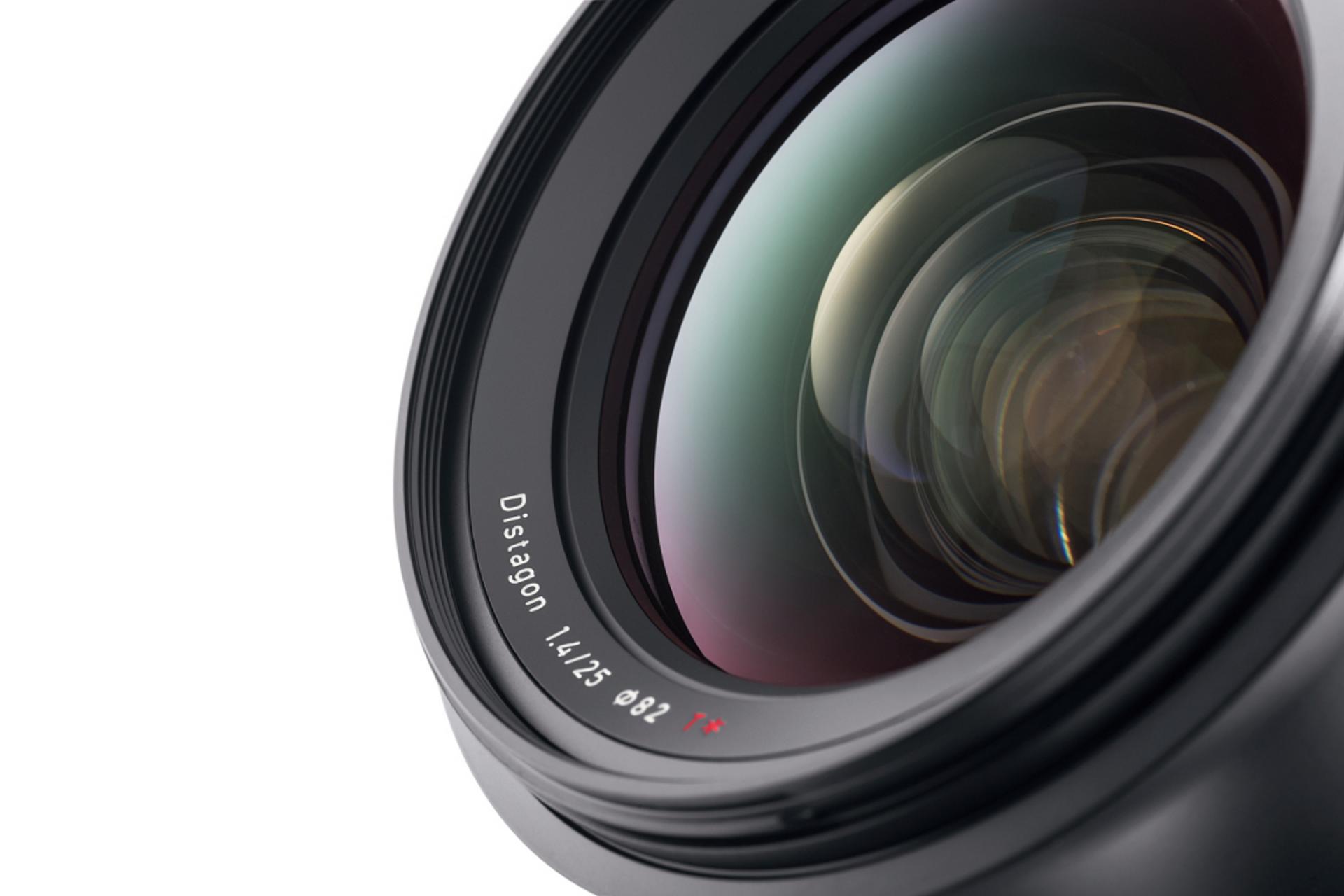 Close-up view of a ZEISS Distagon 1.4/25 camera lens showing detailed glass elements and lens markings.