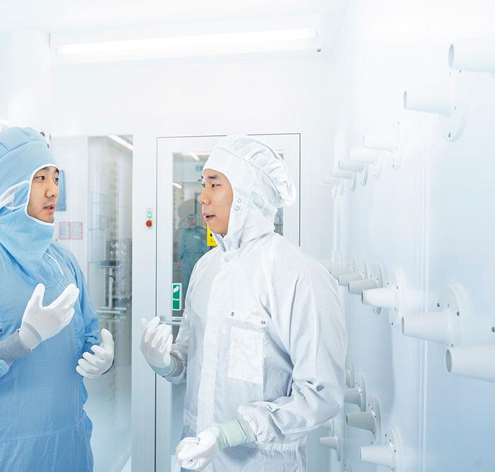 Zwei Mitarbeiter der SMT Process Control Solutions unterhalten sich im Reinraum der ZEISS SMT