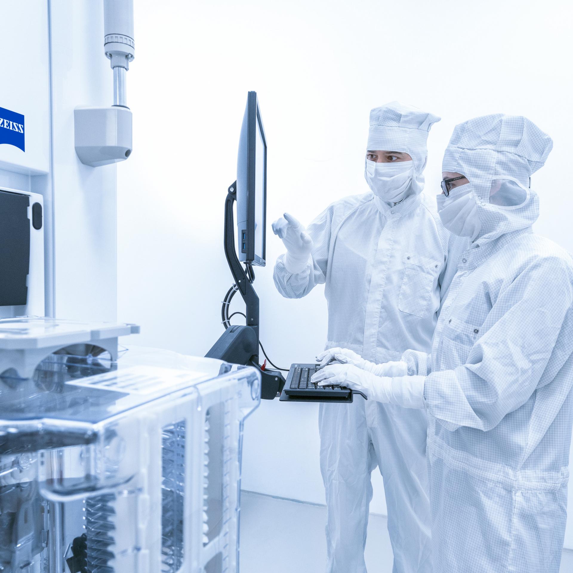 Zwei Mitarbeiter der SMT Process Control Solutions arbeiten im Reinraum der ZEISS SMT