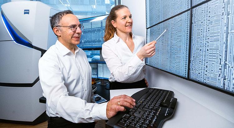 Zwei PCS-MultiSEM Mitarbeiter schauen sich die neueste Technologie auf einem Bildschirm an