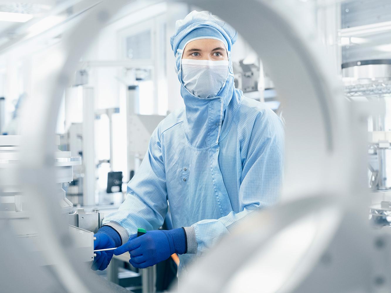 Ein Mitarbeiter im Reinraum fertigt am ZEISS Standort in Wetzlar hochmoderne DUV-Komponenten.