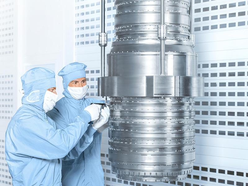Zwei Mitarbeitende arbeiten an einem DUV-Objektiv der Starlith®-19xyi-Serie im Reinraum der ZEISS Semiconductor Manufacturing Technology.